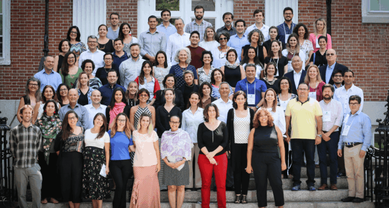 Grupo com cerca de 50 pessoas posicionadas em quatro filas, uma atrás da outra, na escadaria em frente à biblioteca da Universidade Harvard
